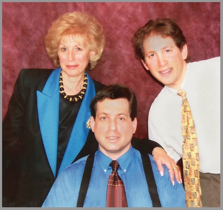 A man and two women posing for the camera.
